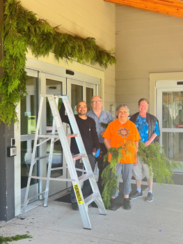 Group of people stand with cedar boughs
