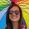 Woman with long brown hair holding an open colourful umbrella.