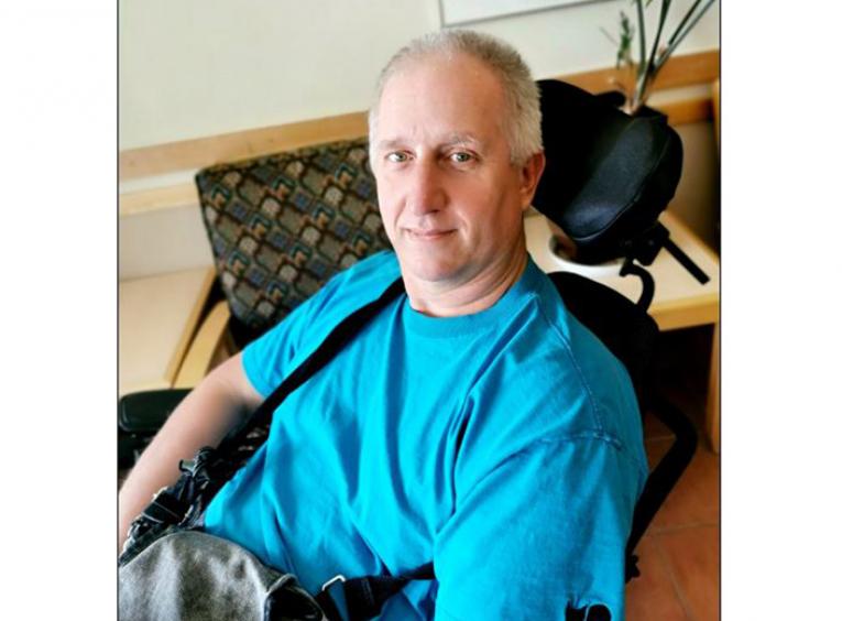 Man sitting in a chair with a blue shirt on