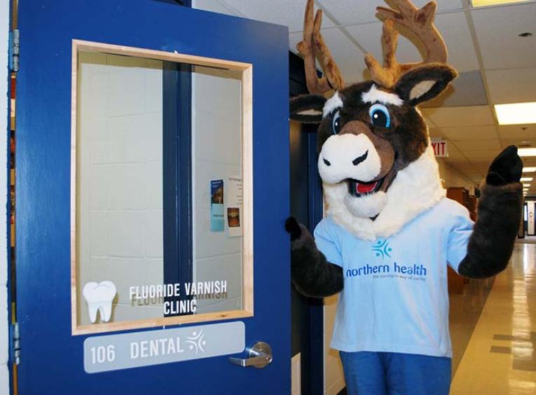 The NH mascot (a giant caribou in a blue shirt) stands next to a dental clinic door
