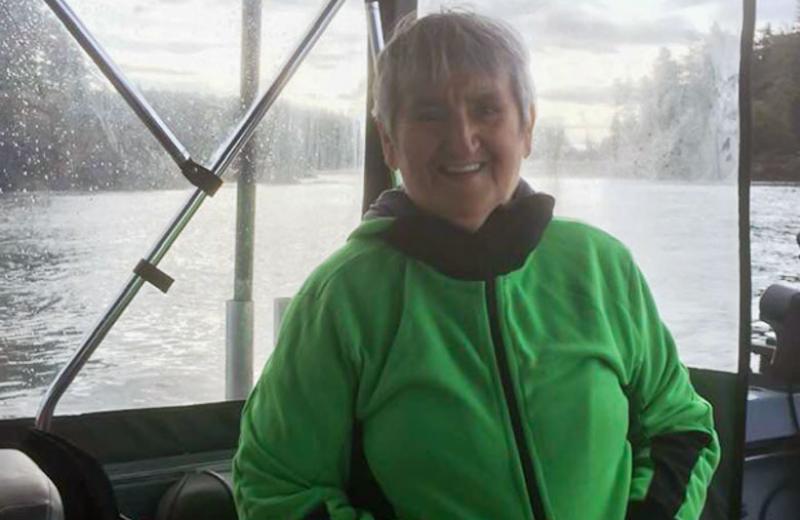 Elder Semiguul sits on a boat, smiling at the camera.